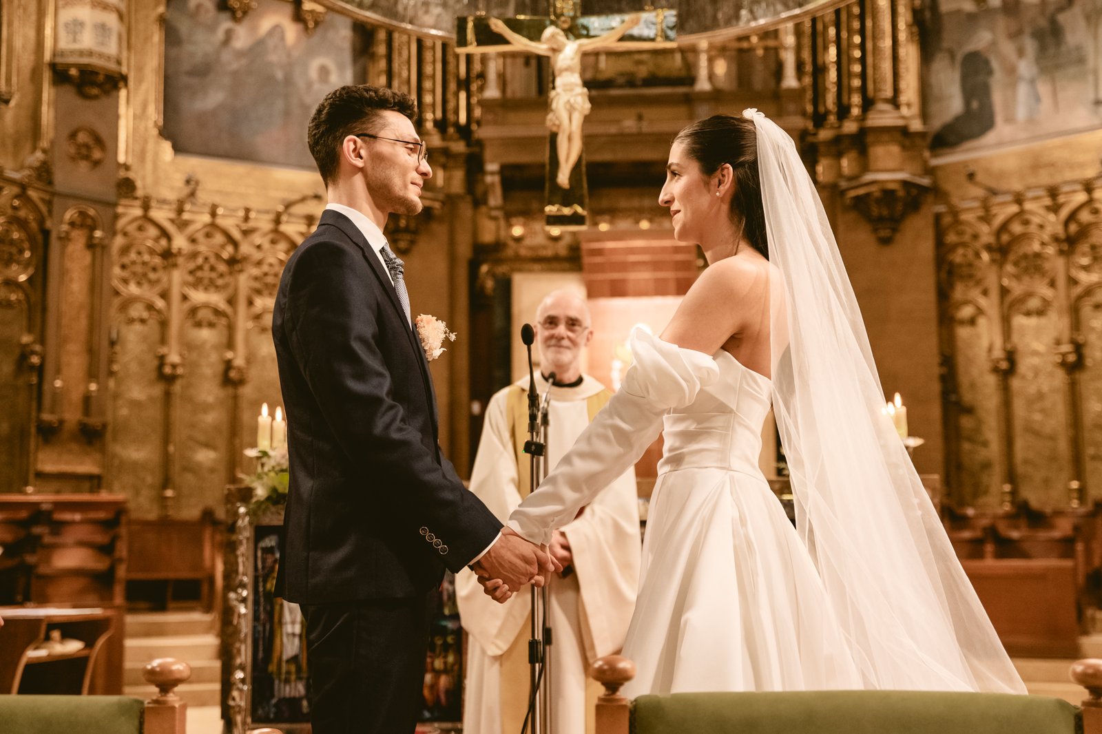 Pareja mirándose en ceremonia interior con columnas doradas
