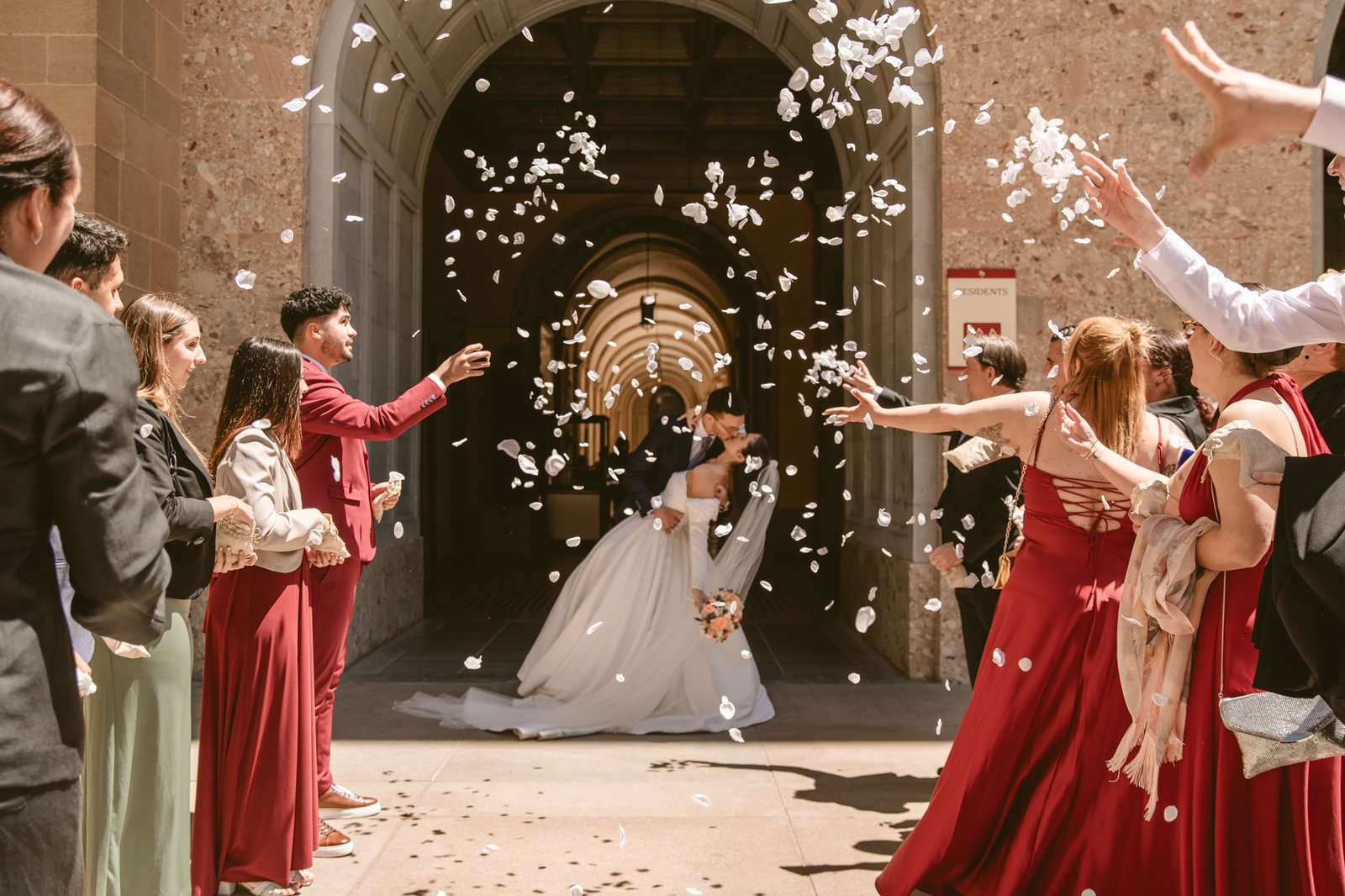 Novia lanzando pétalos con damas de honor en rojo